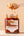 Dumpling held above a jar of Sunnybank chilli crisp oil, with chilli oil dripping from it.