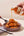 Sunnybank pineapple and habanero hot sauce being poured over a bowl of crispy fried chicken.
